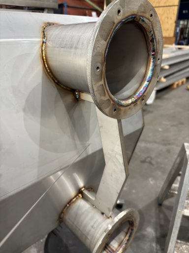 Detail van een metalen buis met lasnaden en bevestigingsflenzen.