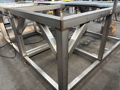 Stalen frame met kruisverbindingen, klaar voor verdere constructie in een werkplaats.