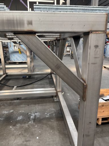 Staalconstructie met een diagonale steunbalk in een industriële omgeving.